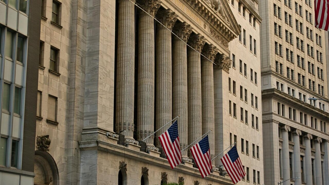 Facade of the New York Stock Exchange building, with Corinthian columns and three US flags