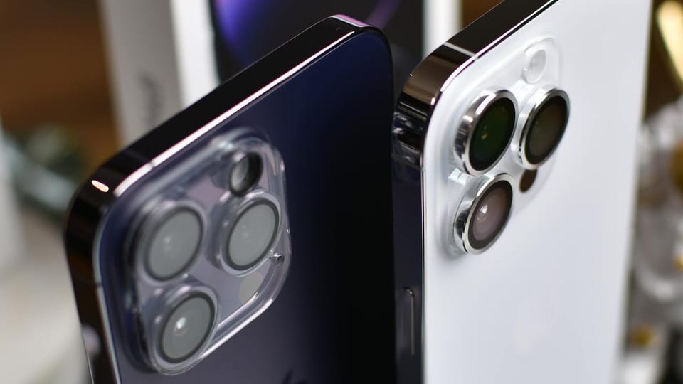Two iPhone 14 Pro Max devices and an iPhone box
