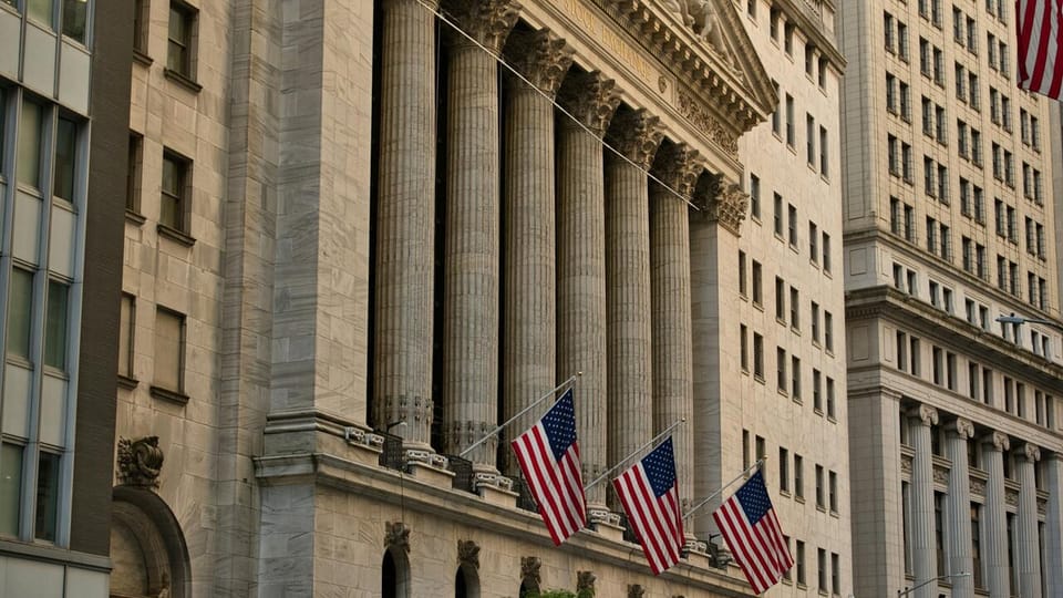 Facade of the New York Stock Exchange building, with Corinthian columns and three US flags