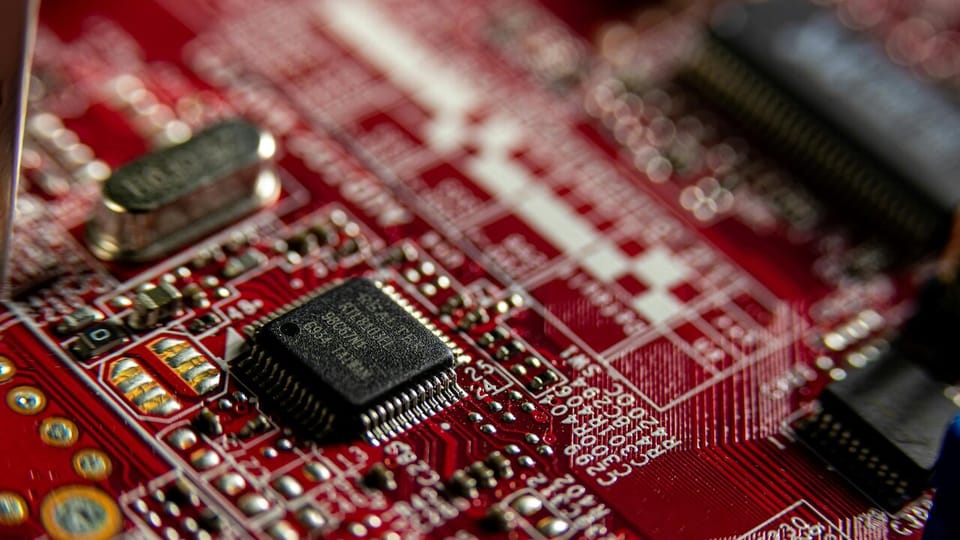 Macro photograph of a red-and-black computer microprocessor on a circuit board.